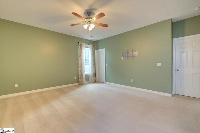 unfurnished room featuring light colored carpet and ceiling fan