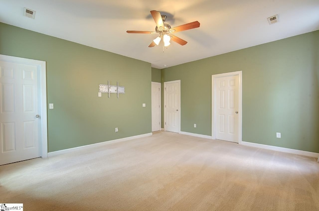 spare room featuring light carpet and ceiling fan