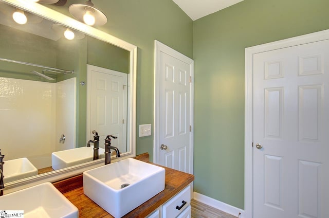 bathroom featuring a shower, vanity, and hardwood / wood-style flooring