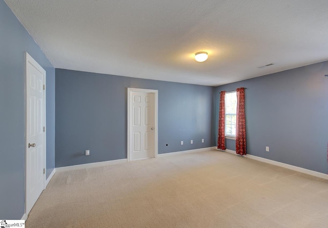 carpeted spare room featuring a textured ceiling