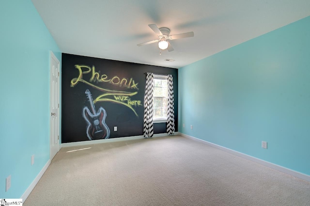 carpeted spare room featuring ceiling fan