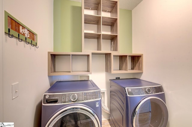 laundry area featuring separate washer and dryer and hardwood / wood-style flooring