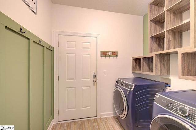 laundry area with light wood-type flooring and washing machine and dryer