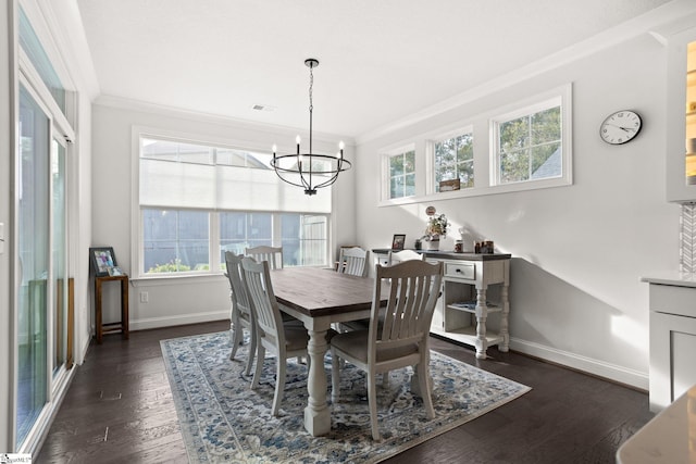 dining area featuring dark hardwood / wood-style floors, an inviting chandelier, and crown molding