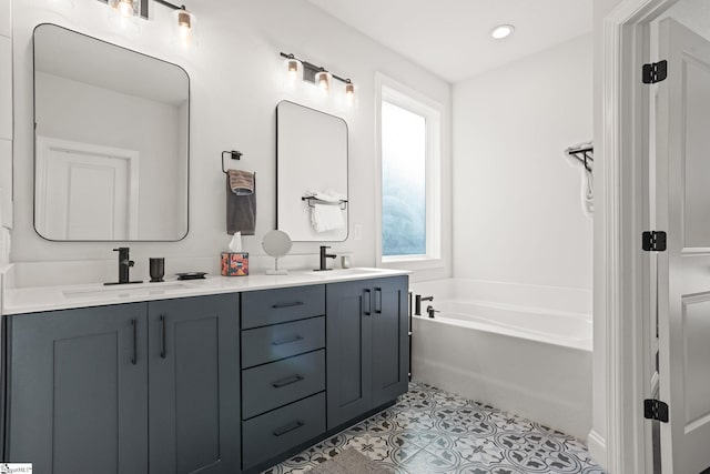 bathroom with a bathtub, vanity, and tile patterned floors