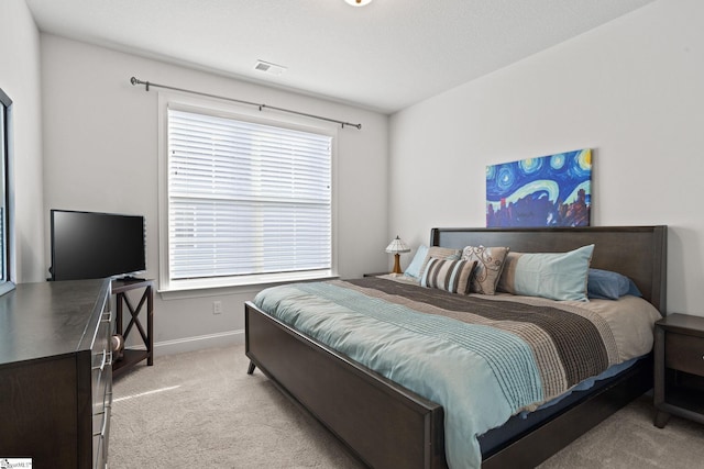 bedroom with multiple windows and light carpet