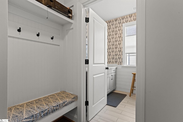 mudroom featuring wood walls