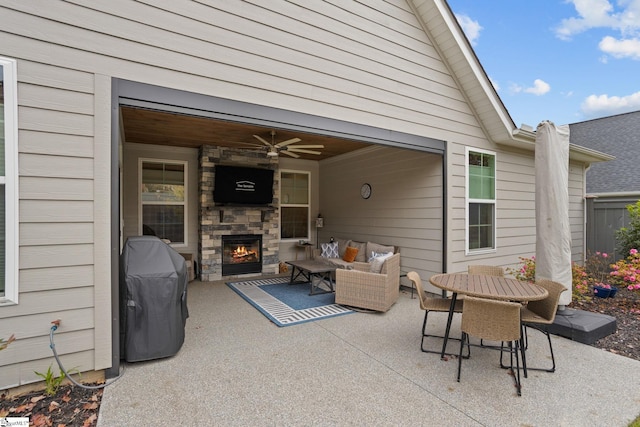 view of patio / terrace with an outdoor living space with a fireplace and ceiling fan