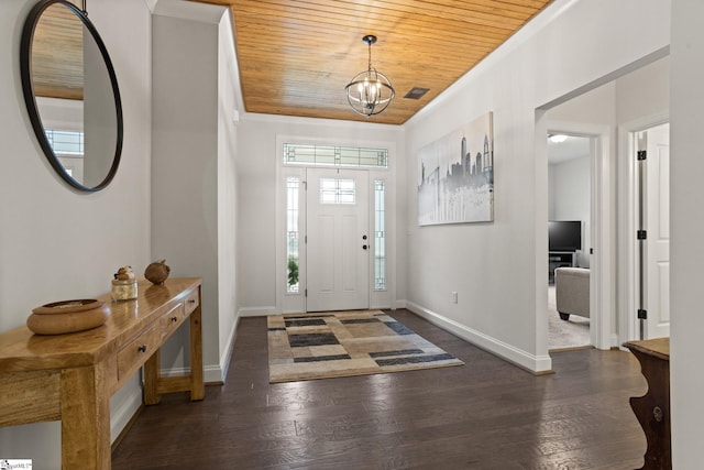 foyer entrance with dark hardwood / wood-style flooring, crown molding, wood ceiling, and an inviting chandelier