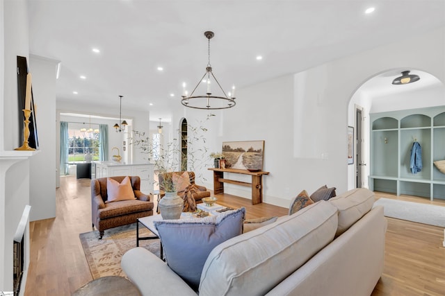 living room with light wood-type flooring and an inviting chandelier