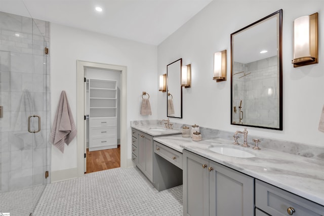 bathroom with tile patterned flooring, vanity, and a shower with door