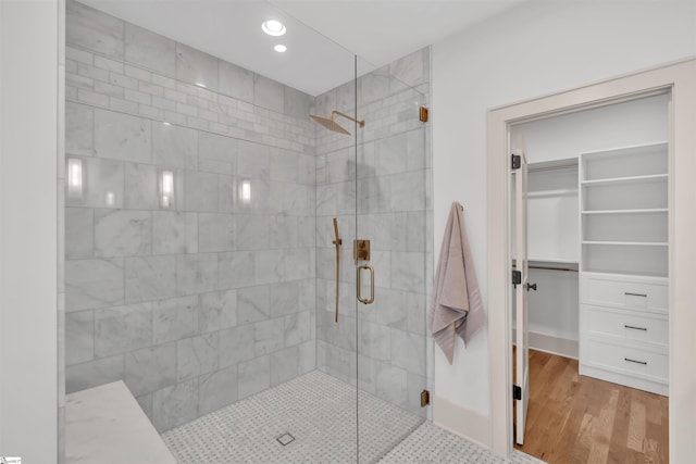 bathroom featuring wood-type flooring and a shower with shower door