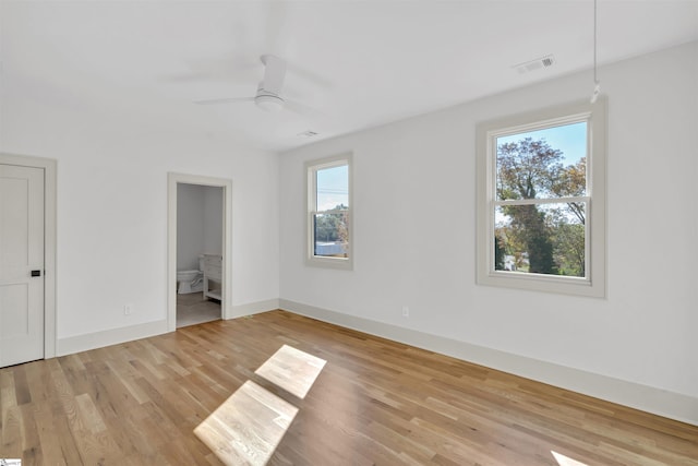 unfurnished bedroom featuring ensuite bath, light hardwood / wood-style floors, and ceiling fan