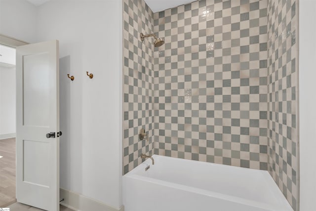 bathroom with hardwood / wood-style flooring and tiled shower / bath