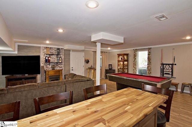 rec room with light hardwood / wood-style floors, crown molding, billiards, and a fireplace