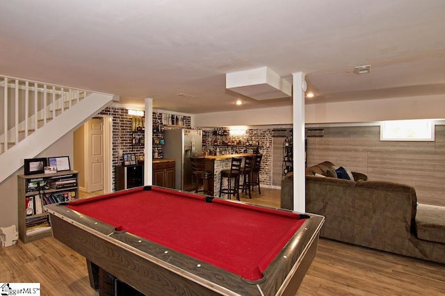 recreation room with hardwood / wood-style floors, bar area, wood walls, and billiards