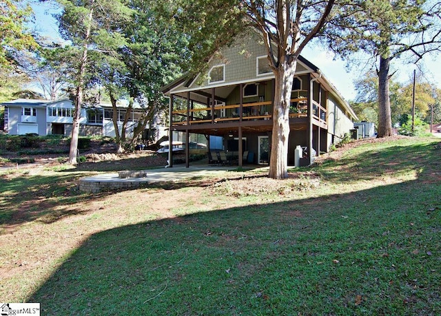 rear view of house featuring a wooden deck and a yard