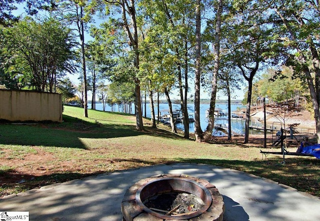 view of yard featuring a water view and a fire pit