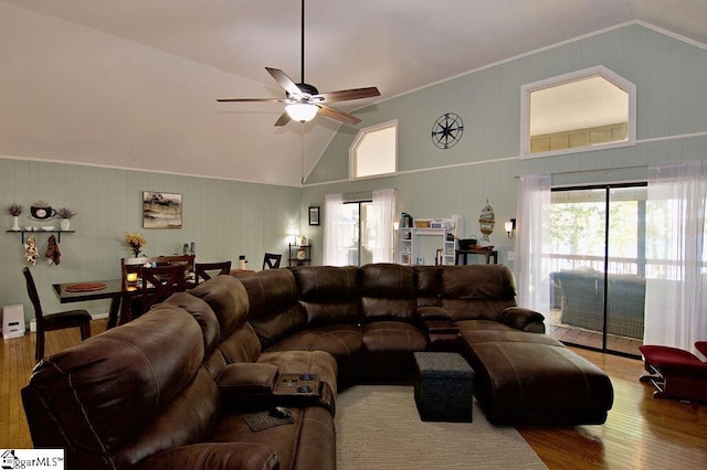 living room with hardwood / wood-style floors, ceiling fan, crown molding, and high vaulted ceiling