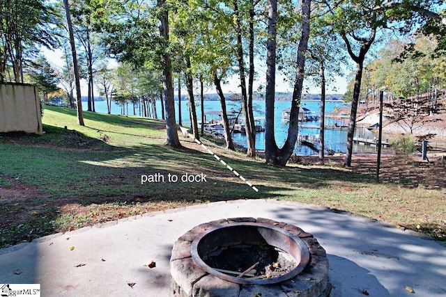 view of yard featuring a water view and a fire pit