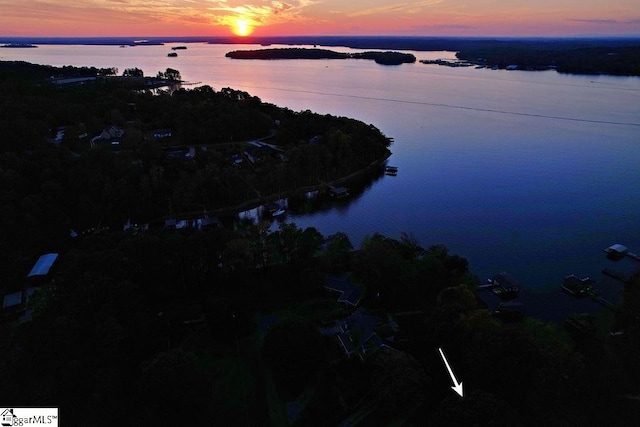 aerial view at dusk featuring a water view