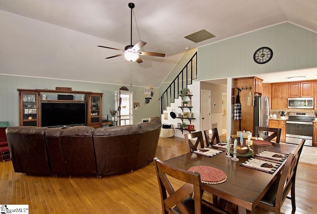 dining room with ceiling fan, light hardwood / wood-style flooring, and vaulted ceiling