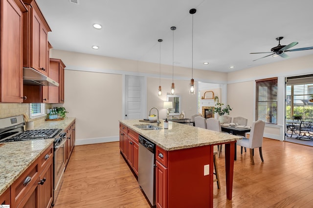 kitchen with light stone counters, stainless steel appliances, a kitchen island with sink, and a breakfast bar area