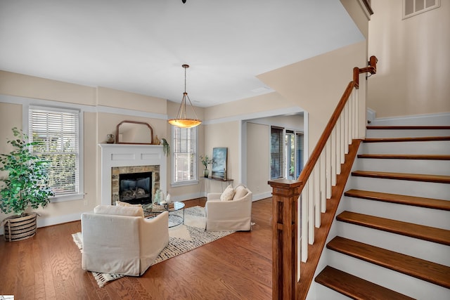 living room with a tiled fireplace and hardwood / wood-style floors