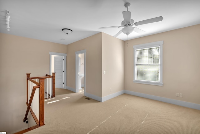 spare room with ceiling fan and light carpet