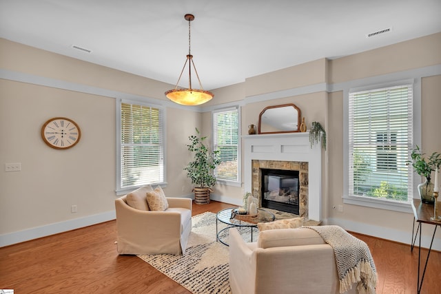 living room with a tiled fireplace and light hardwood / wood-style flooring