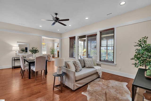 living room featuring ceiling fan and hardwood / wood-style floors