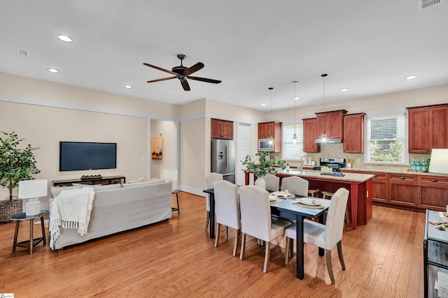 dining area featuring ceiling fan, light hardwood / wood-style flooring, and sink