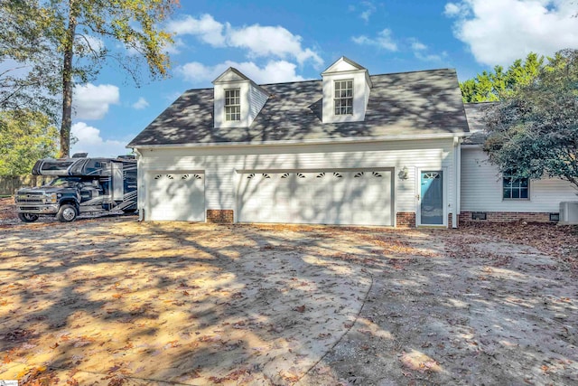 exterior space featuring central AC unit and a garage