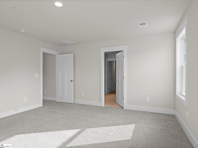 unfurnished room featuring light colored carpet