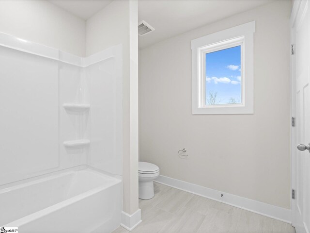 bathroom with toilet and tub / shower combination