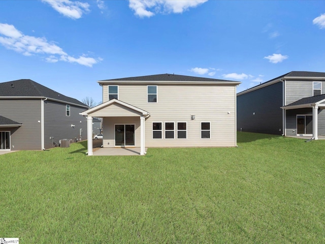 rear view of property with cooling unit, a patio, and a lawn