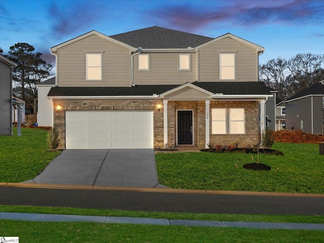 view of front of property featuring a garage and a yard