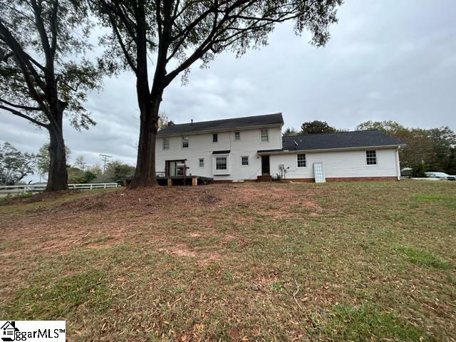 rear view of property with a lawn