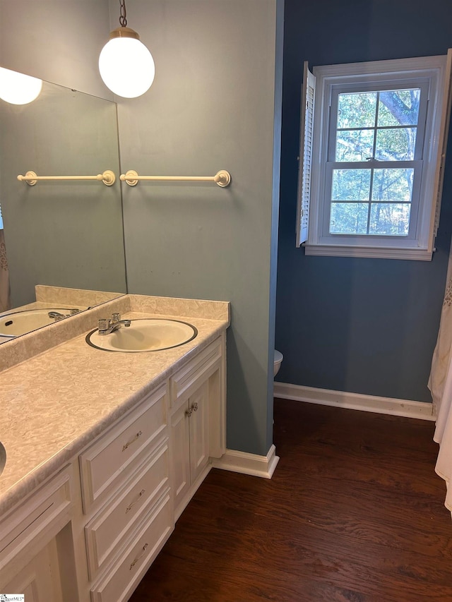 bathroom featuring wood-type flooring, vanity, and toilet