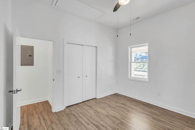 unfurnished bedroom with ceiling fan, electric panel, and light hardwood / wood-style flooring