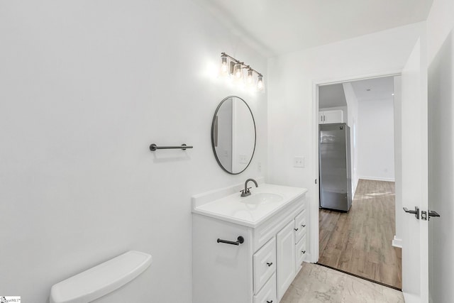 bathroom with vanity, wood-type flooring, and toilet