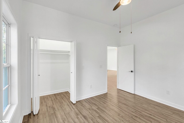 unfurnished bedroom featuring ceiling fan, light wood-type flooring, and a closet