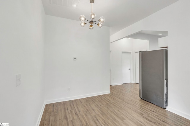 interior space featuring a notable chandelier and light wood-type flooring