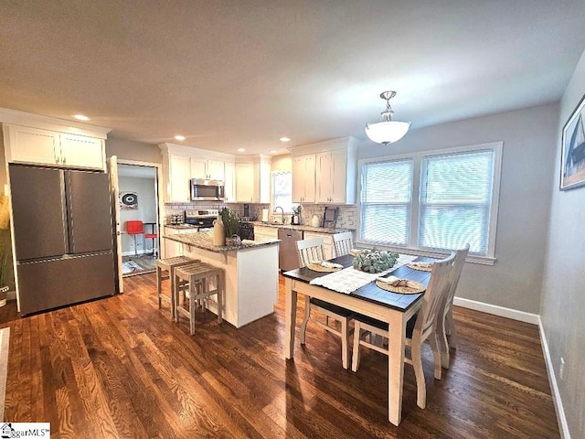 dining area featuring sink and dark hardwood / wood-style flooring