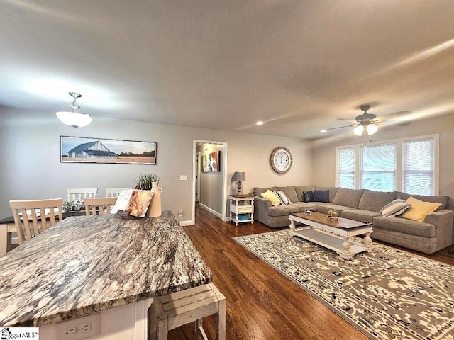 living room with dark wood-type flooring and ceiling fan