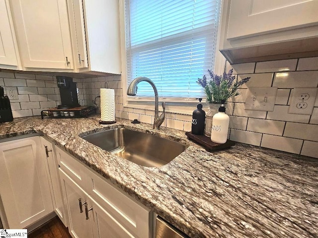 kitchen with white cabinetry, sink, tasteful backsplash, and stone counters