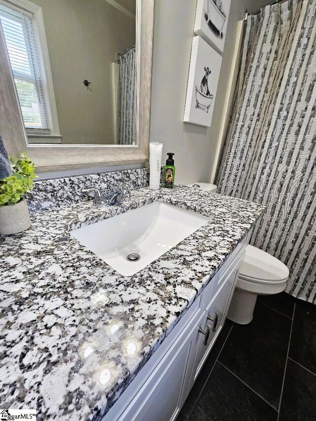 bathroom featuring vanity, tile patterned floors, and toilet