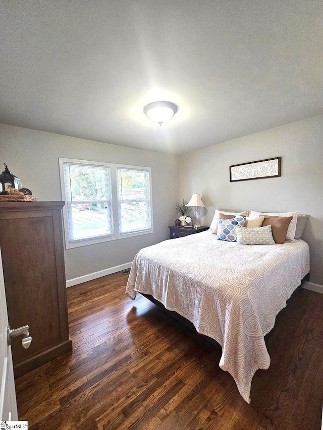 bedroom with dark hardwood / wood-style floors