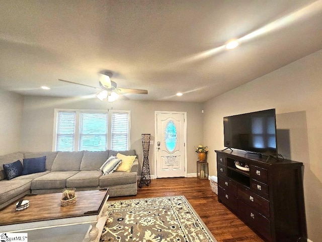 living room with dark hardwood / wood-style flooring, lofted ceiling, and ceiling fan