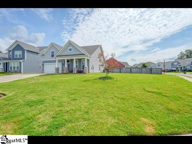 view of front of house featuring a porch, a front yard, and a garage